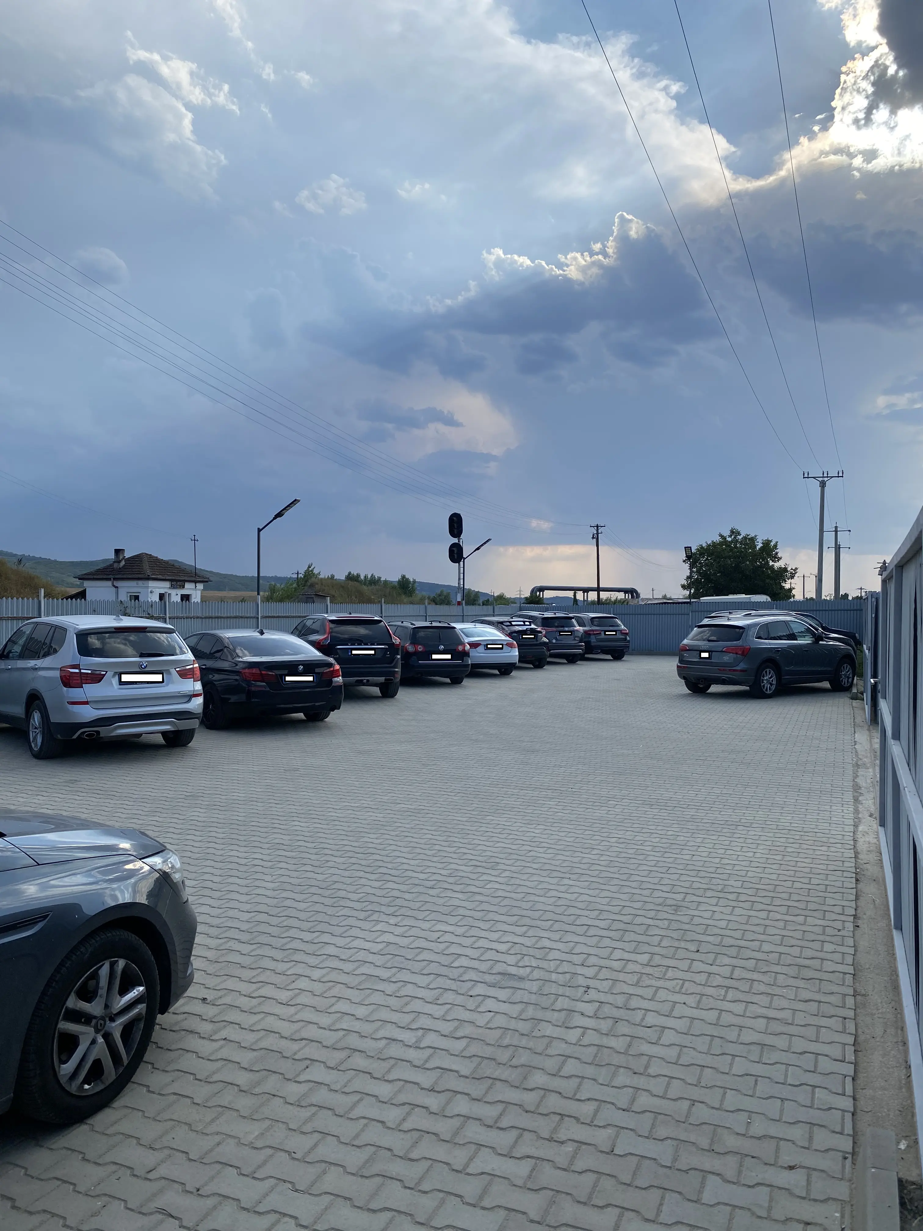 Mașini parcate la intrarea parcării pavate și monitorizate